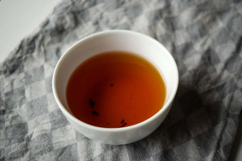 Weiße Teetasse mit schwarzem Tee