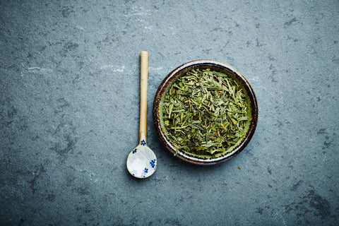 Long Jing Grünteeblätter in einem dunklen Schüssel