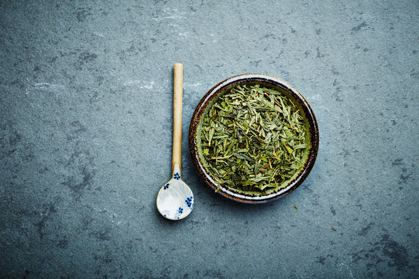 Long Jing Grünteeblätter in einem dunklen Schüssel