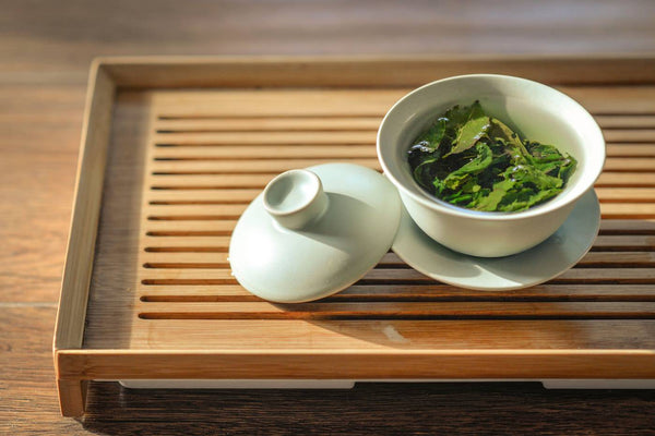 Dampfende Tasse mit Teeblättern, während sich die Aromen entfalten und der Tee seine optimale Ziehzeit erreicht