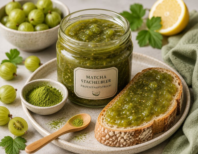 Selbstgemachter Matcha-Stachelbeer-Fruchtaufstrich in einem Glas mit frischen Stachelbeeren und Matcha-Pulver.